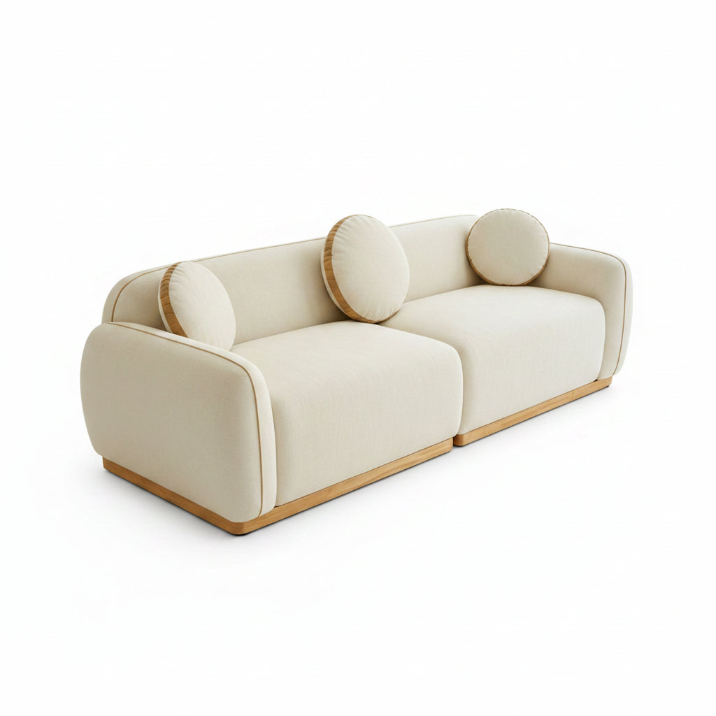 Beige sofa with circular cushions in a bright room with large windows.