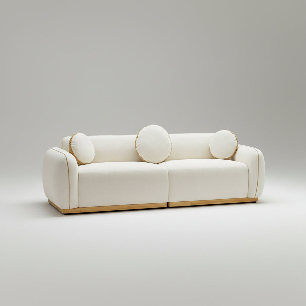 White sofa with circular cushions in a room with large windows showing a mountain view.