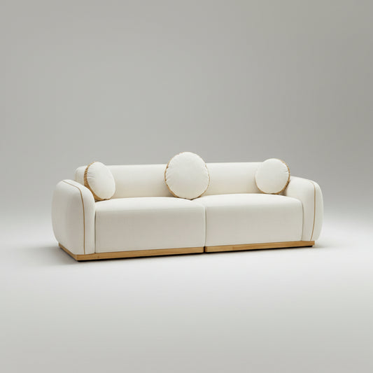 White sofa with circular cushions in a room with large windows showing a mountain view.